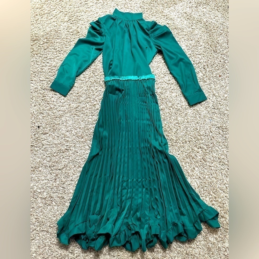 PLEATED SKIRT WITH RUFFLES AND A HIGH NECK BLOUSE .